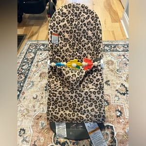 Leopard baby bjorn bouncy chair with toy bar.